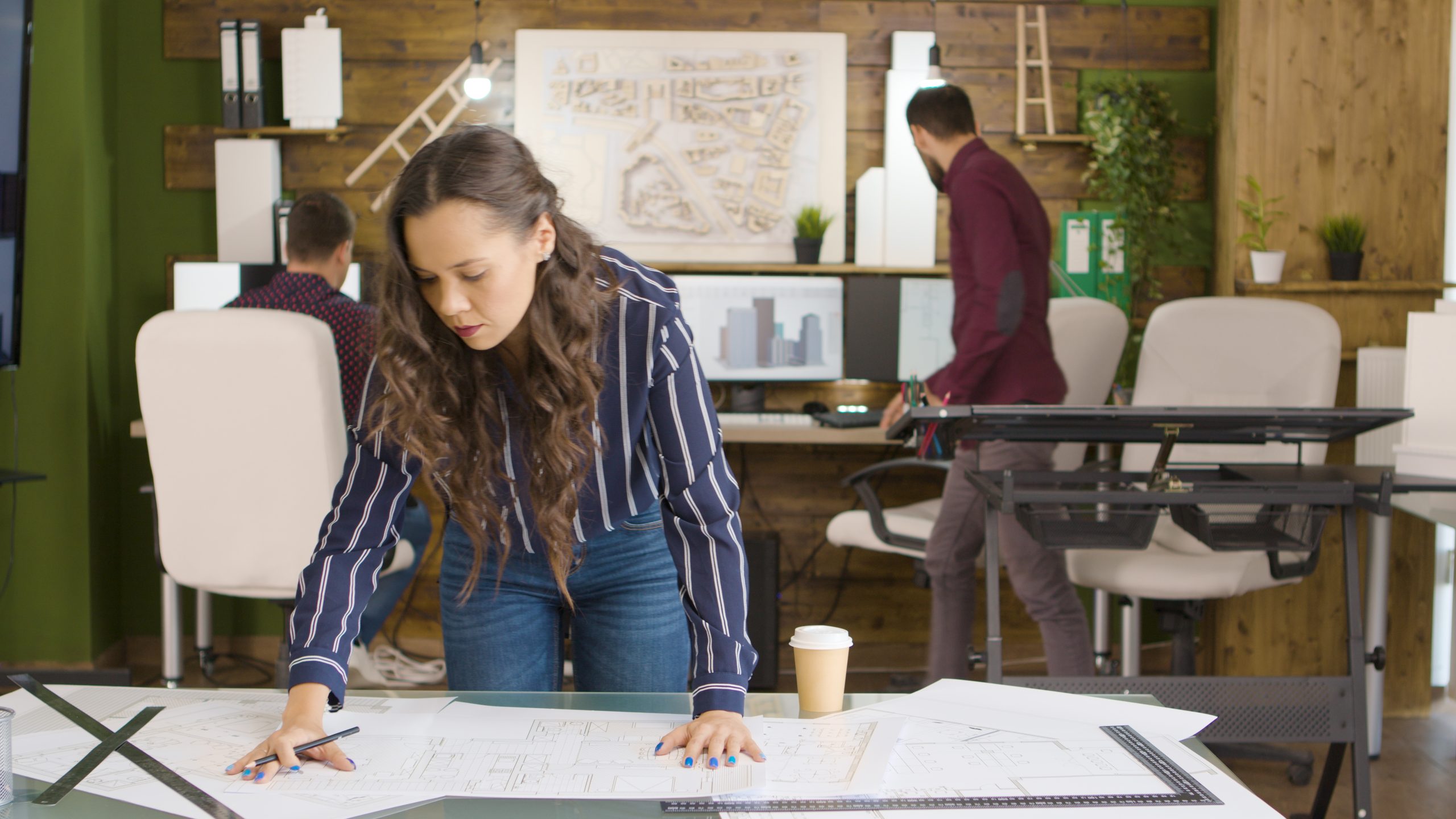 An architecture student working on a detailed building model in a design studio.